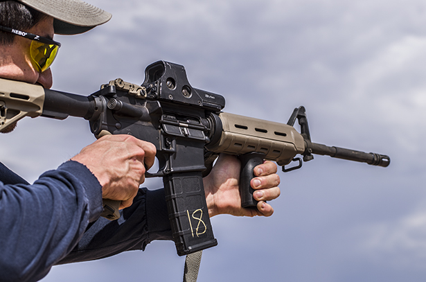 A man firing a Bushmaster AR-15.